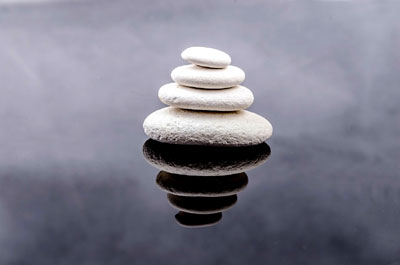 Stacked rocks reflected in water as an example of balance