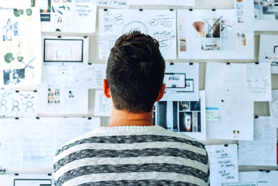 Man staring at a design idea board
